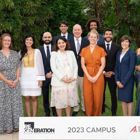 Young Leaders group photo behind placard that reads Re.Generation Future Leaders and Prince Albert II of Monaco Foundation