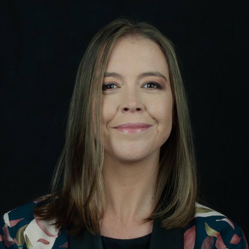 Portrait of Camila Escallón in floral top against black background