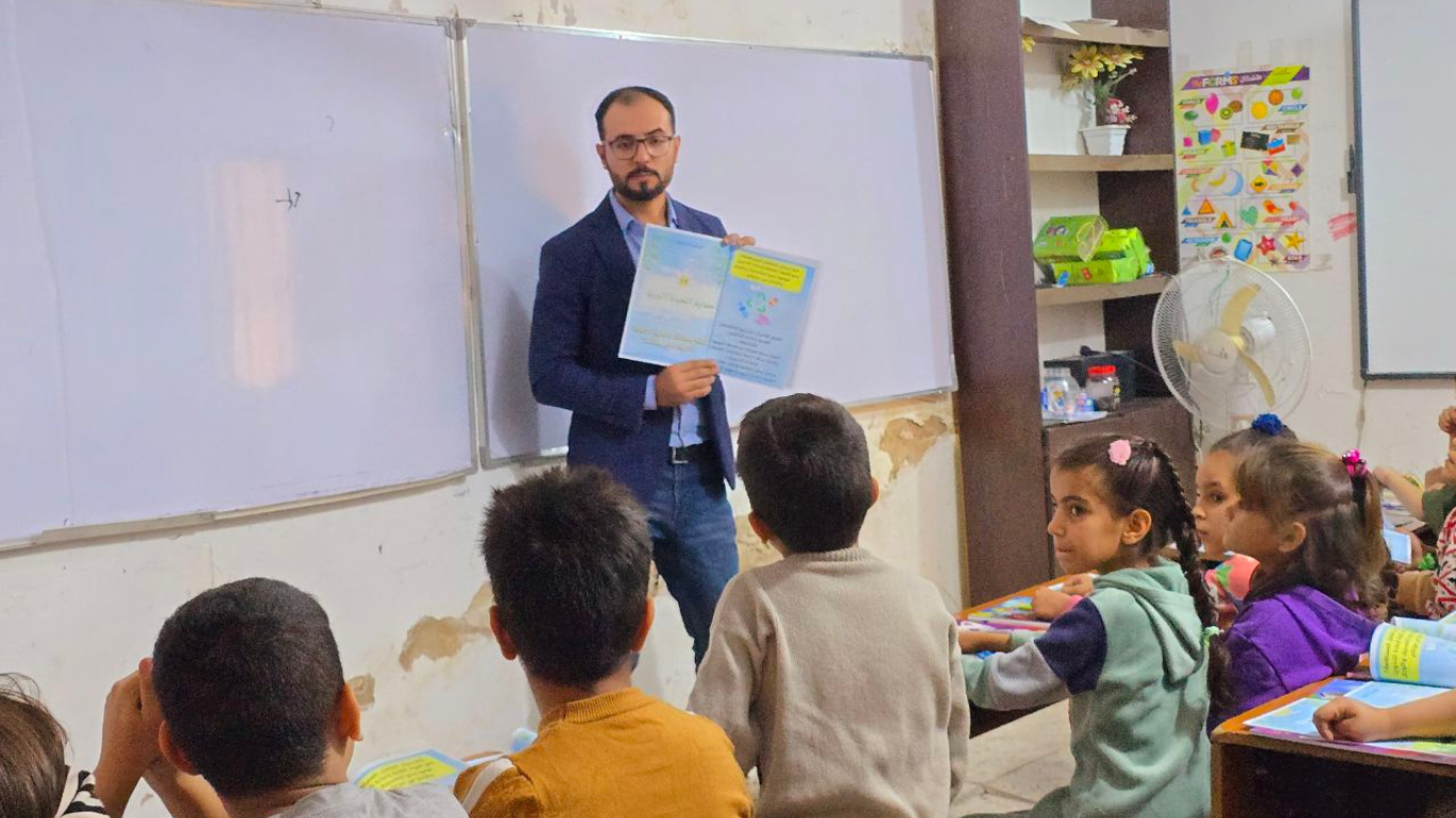 Hasan teaching a group of school children