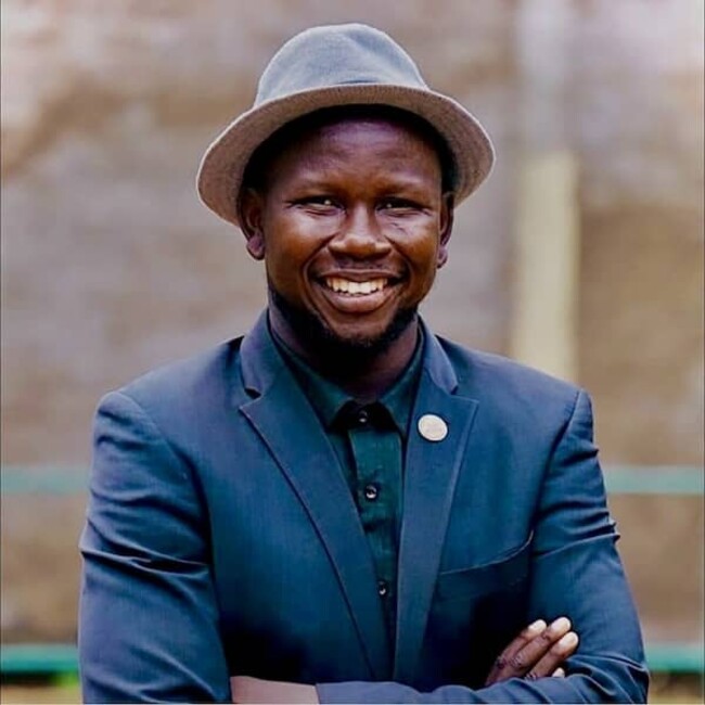 Elihu Jos Benam in dark blue blazer and hat