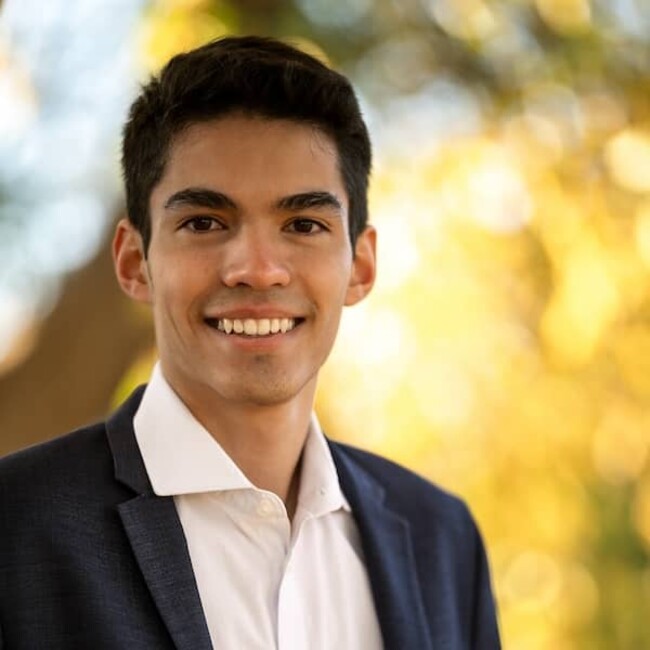 Gabriel Nagel in white shirt and dark blue blazer against blurred outside background