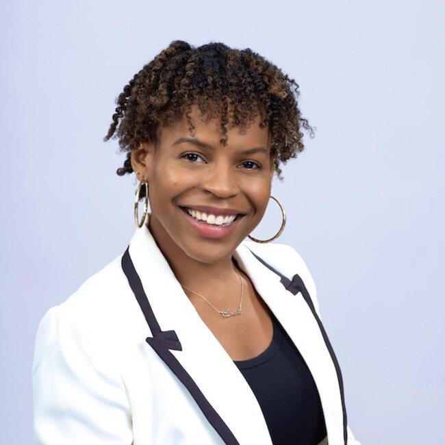 Lashyra Nolen in white overcoat blazer against light blue background