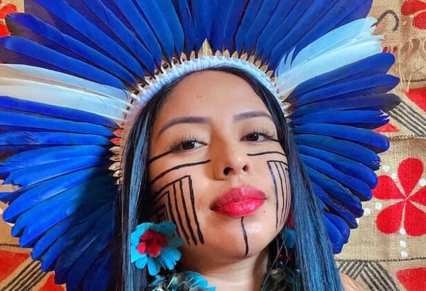 Maricelma Francelino Fialho Cândido wearing Indigenous headwear and face paint