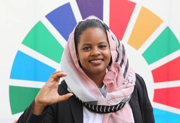 Photo de Nisreen Elsaim contre la roue des couleurs des ODD de l'ONU