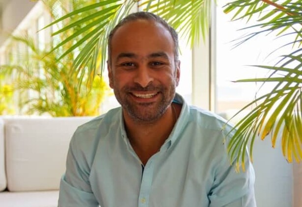 Seif Taher in casual light green shirt against a background of white sofa and indoor plants